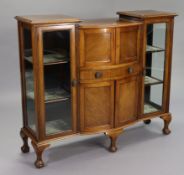 A Victorian mahogany bow-front china display cabinet enclosed by two pairs of panel doors & a long