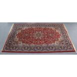 A vintage Persian large rug of crimson & ivory ground with central medallion surrounded by repeating