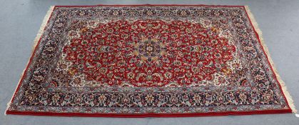 A vintage Persian large rug of crimson & ivory ground with central medallion surrounded by repeating