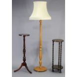 A beech standard lamp with a fluted & vase-turned centre column & on circular base, together with