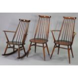 An Ercol spindle-back rocking chair with hard seat, & two similar dining chairs.