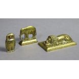 A 19th century cast brass model of a sleeping lion, on flat rectangular base, 7¼” wide; a ditto