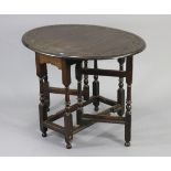 A carved oak oval gate-leg occasional table on baluster-turned supports & turned feet with plain