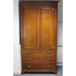 A late 19th/early 20th century mahogany wardrobe with a moulded cornice, enclosed by a pair of