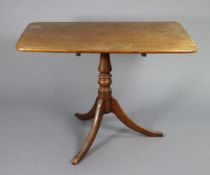 An early 19th century mahogany pedestal table with plain rectangular tilt-top on turned centre