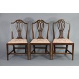 A pair of Hepplewhite-style mahogany dining chairs with pierced splat-backs & padded drop-in