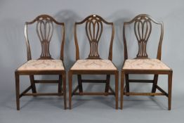 A pair of Hepplewhite-style mahogany dining chairs with pierced splat-backs & padded drop-in