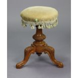 A Victorian carved walnut piano stool with a padded revolving seat, & on a vase-turned centre column