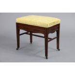 A Victorian mahogany-frame piano stool with padded hinged seat upholstered yellow silk fabric, on
