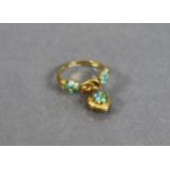 A Victorian gold ring set clusters of turquoise beads either side of a lover’s knot, from which is