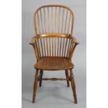 An 18th century ash, & elm Windsor elbow chair, with hooped spindle-back, hard seat & on