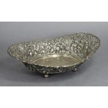 An Indonesian white metal oval dish, the pierced sides embossed with stylised flowers & scrolls,