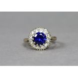 A 9ct gold ring set round-cut blue stone within a border of small white stones, size K, 3.4g.