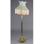 An Edwardian brass Corinthian column standard lamp, on square rouge marble base with four brass