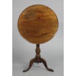 A mahogany tripod table with moulded edge to the circular tilt-top, on turned centre column &