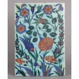 AN IZNIK POTTERY TILE, 19th century or possibly earlier, decorated with flowers on a pale blue