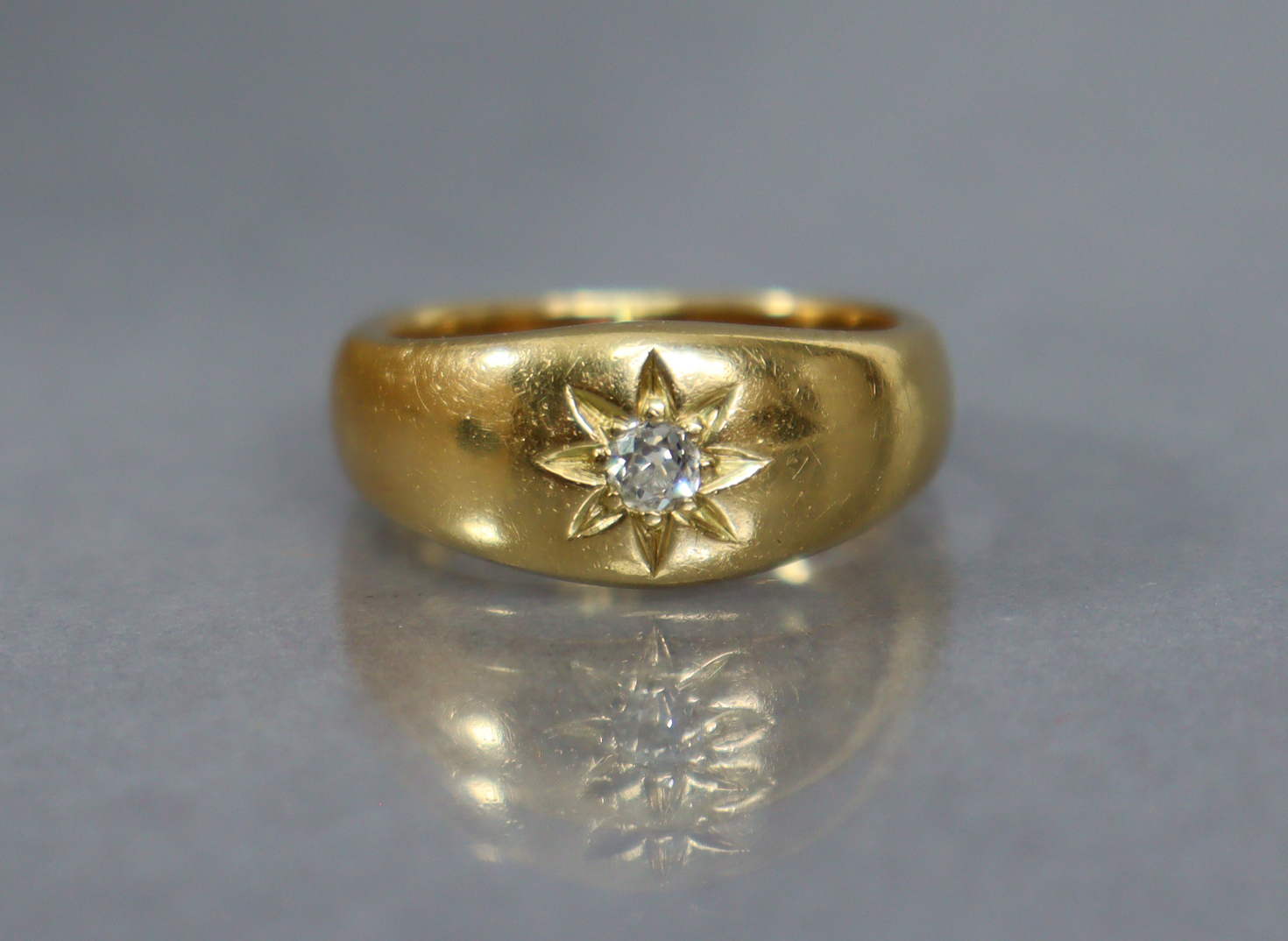 An Edwardian heavy 18ct. gold gent’s ring, gypsy-set with a small diamond; size: S; weight: 14.7gm.