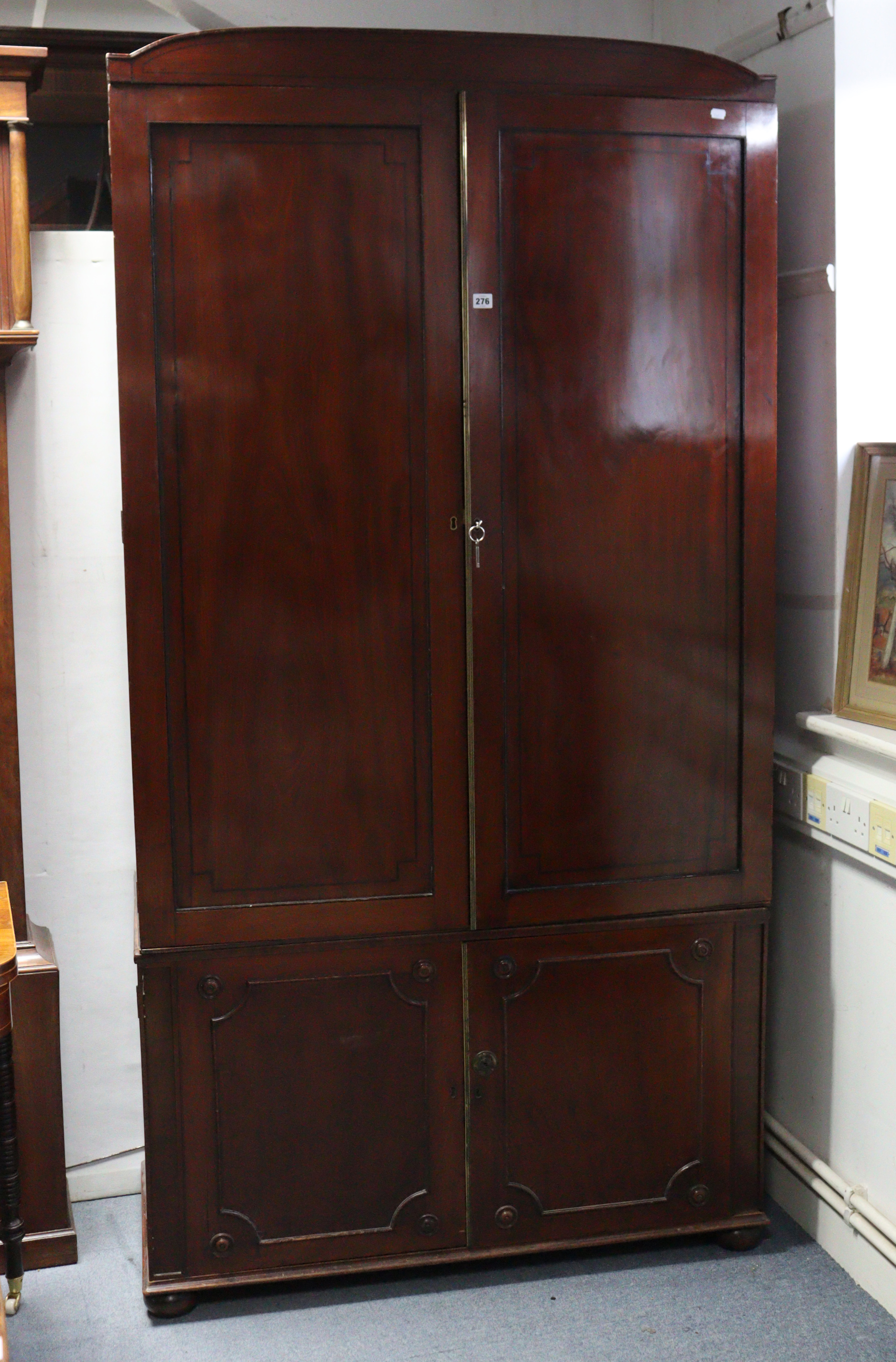 A 19th century inlaid mahogany wardrobe with a hanging compartment enclosed by pair of panel