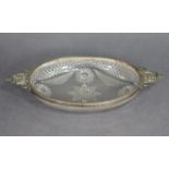 A late Victorian cut glass oval shallow dish with silver-mounted rim & cast pierced flat handles