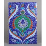 A 19th century Iznik pottery tile, with floral decoration on a blue scaled ground, 9¾” x 6½”.