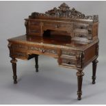 A 19th century carved oak writing table fitted with five drawers to the stage back, with a carved