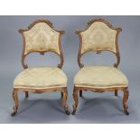 A pair of Victorian birch frame bedroom chairs with shaped & carved padded backs & seats, on