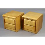 A pair of light oak-finish two-drawer bedside chests, 18¾” wide x 18¾” high.