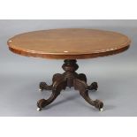 A 19th century mahogany pedestal dining table with an oval tilt-top; & on a carved vase-turned