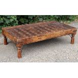 A Chinese hardwood large low coffee table inset plate-glass to the rectangular carved top, & on four