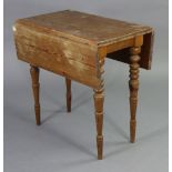 A pine drop-leaf kitchen table on four turned & tapered legs, 29” wide x 29¾” high.
