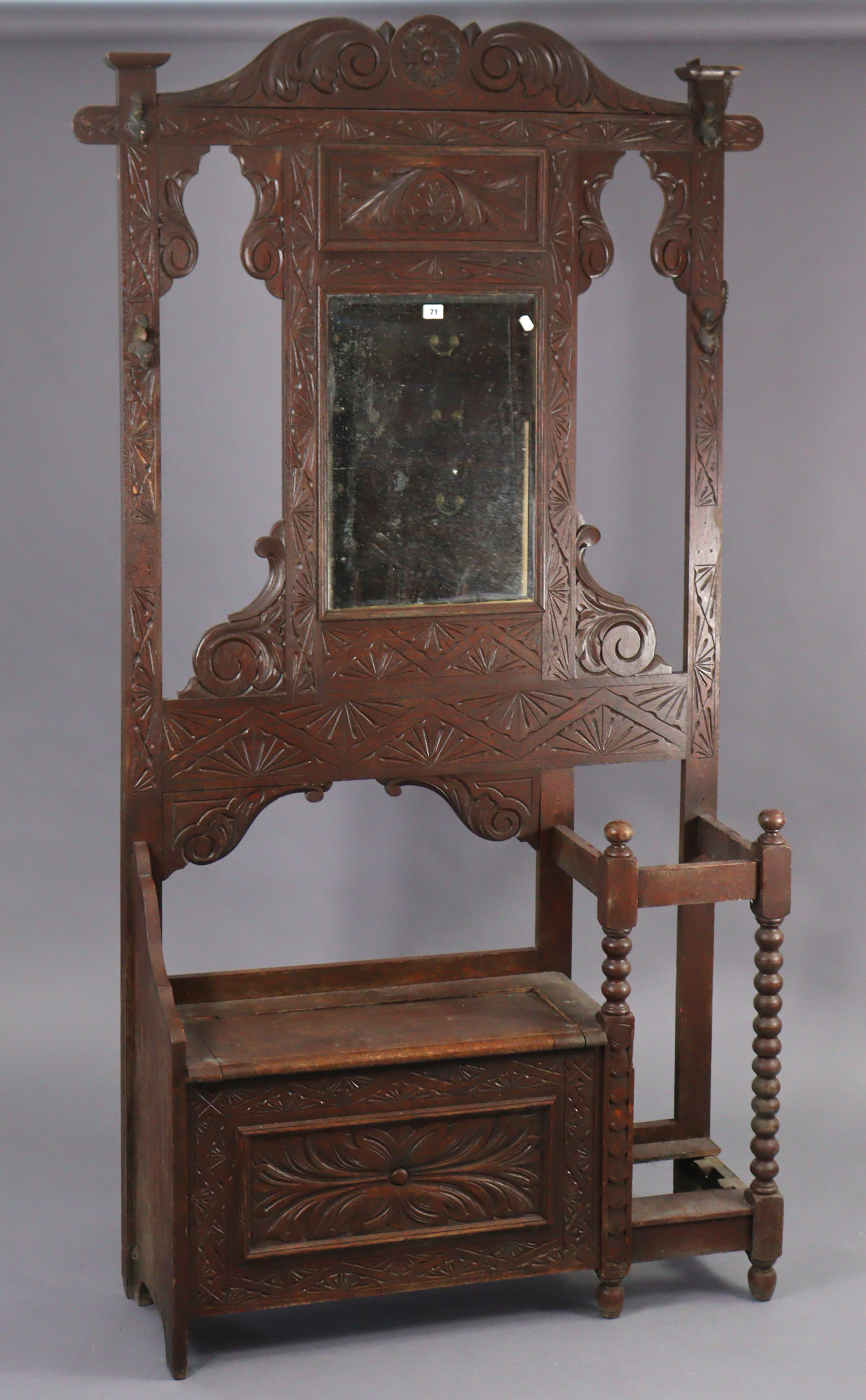 A 1930’s carved oak hall stand inset bevelled rectangular mirror to top, with a hinged box seat &