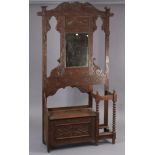 A 1930’s carved oak hall stand inset bevelled rectangular mirror to top, with a hinged box seat &