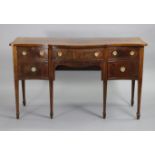 A regency-style serpentine-front mahogany sideboard, with crossbanded rectangular top, fitted single