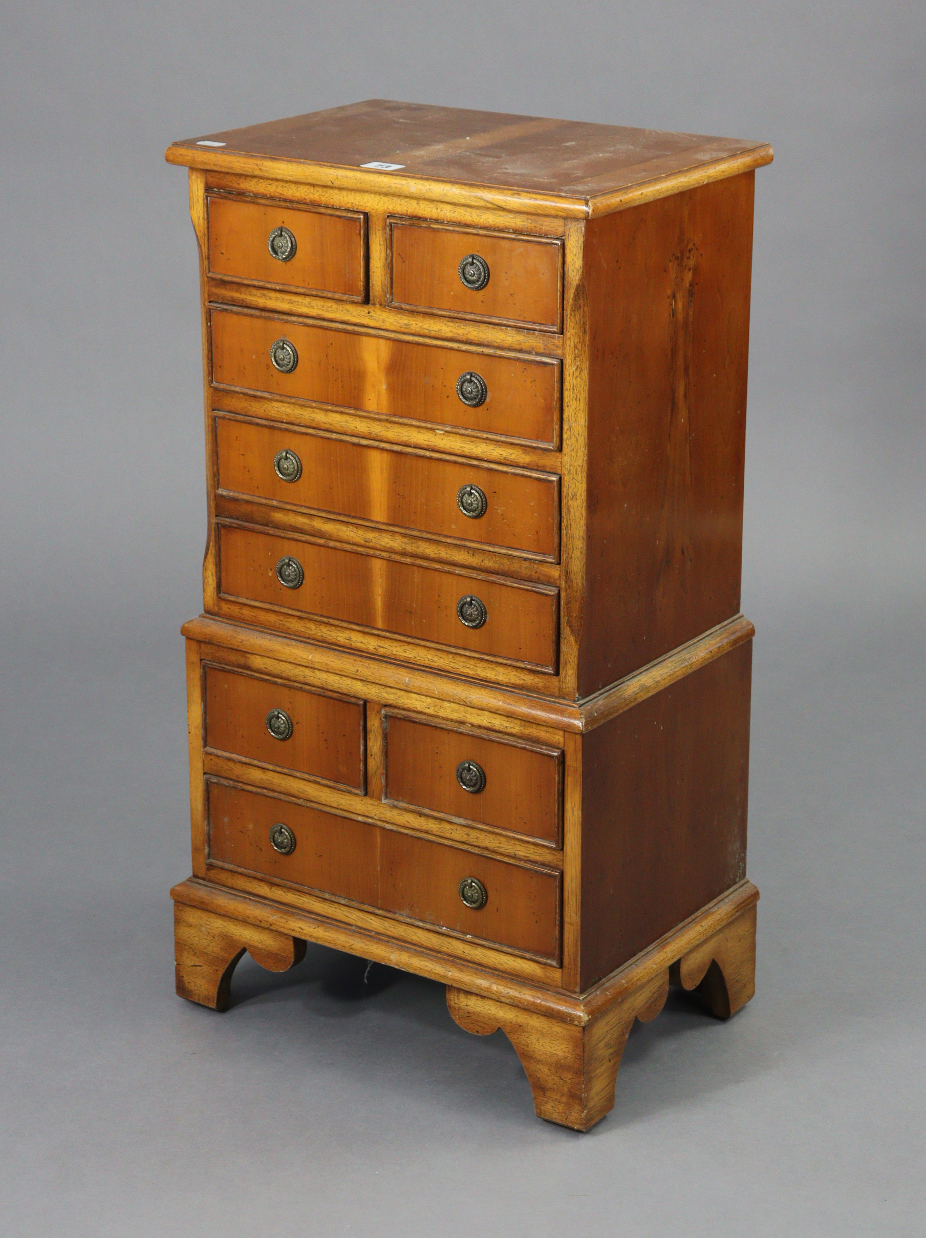 A reproduction yew wood small chest-on-chest fitted with an arrangement of four short & four long
