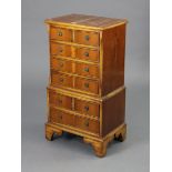 A reproduction yew wood small chest-on-chest fitted with an arrangement of four short & four long