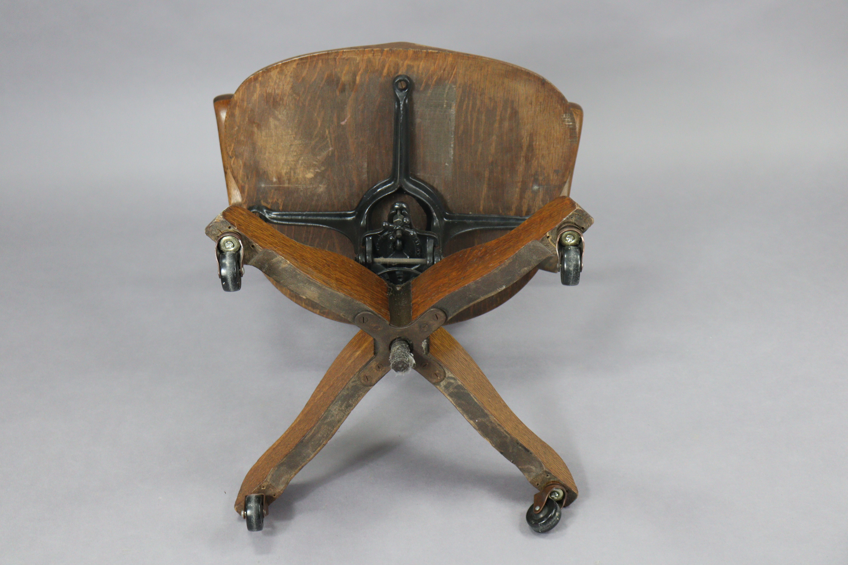 An oak revolving desk chair with a shaped splat back, hard seat & on a sprung base with four splay - Image 7 of 7