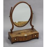 A 19th century inlaid-mahogany oval swing toilet mirror fitted three drawers to the serpentine-front