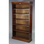 A mahogany tall standing six-tier open bookcase with a moulded Greek-key frieze, & on a plinth base,