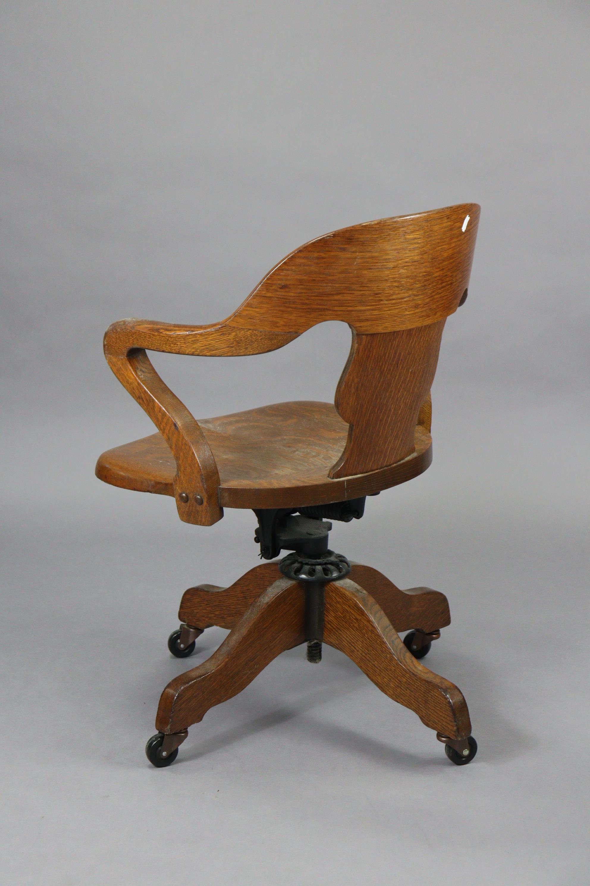 An oak revolving desk chair with a shaped splat back, hard seat & on a sprung base with four splay - Image 4 of 7