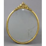 A 19th century gilt frame oval wall mirror with a raised vine-leaf surmount, 29½” x 23”.