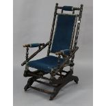 A Victorian beech-frame rocking chair with a padded seat & back, & on a sprung base.