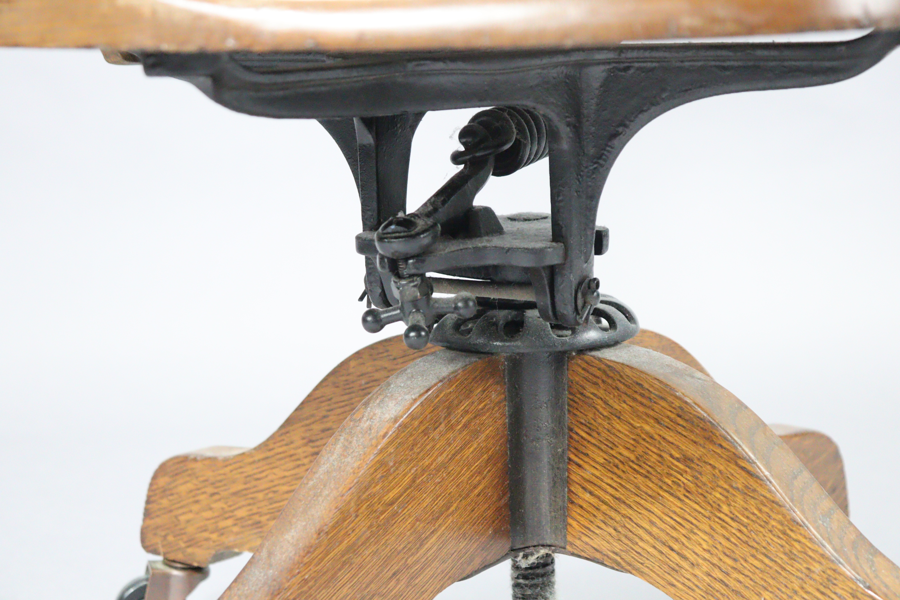 An oak revolving desk chair with a shaped splat back, hard seat & on a sprung base with four splay - Image 6 of 7