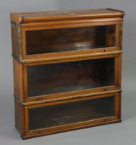 A Globe Wernicke oak three-tier sectional bookcase, each tier enclosed by a glazed lift-up door, 34”