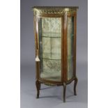 A 19th century continental mahogany bow-front display cabinet with gilt-metal mounts, rouge marble