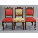 Three early 20th century carved oak rail-back dining chairs with padded seats & backs, & on turned