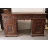 A late 19th/early 20th century carved oak pedestal sideboard fitted three frieze drawers, & each