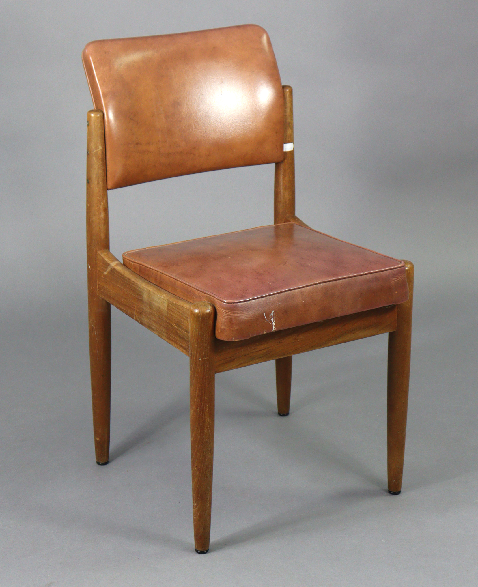 A mid-20th century teak side chair with a padded seat & back upholstered pig skin, & on round