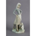 A Lladro porcelain ornament in the form of a standing female figure with a goose & a bucket at her