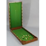 A vintage mahogany folding bar-billiards table, 21¾” wide x 84” long (open), with balls.