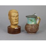 A carved wooden male head, on circular plinth inscribed “Christys Hats”, 9¾” high; & a majolica-type